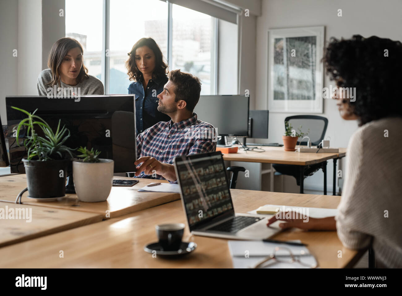 Vielfältige Gruppe von jungen Designern gemeinsam auf einem Computer Stockfoto