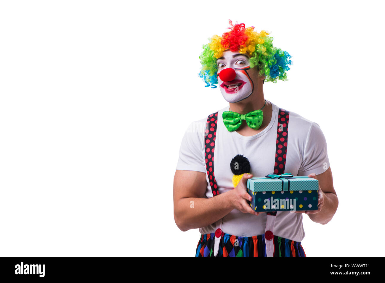Lustiger Clown mit einer vorliegenden Geschenkbox isoliert auf weißem Hintergrund Stockfoto