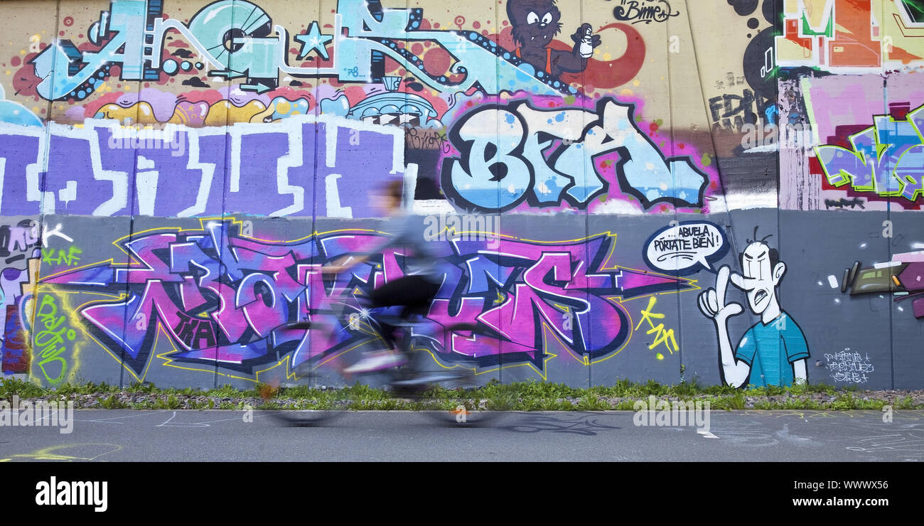 Radfahrer auf Schiene Radweg Nordbahntrasse vor Graffiti Wall, Wuppertal, Deutschland, Europa Stockfoto