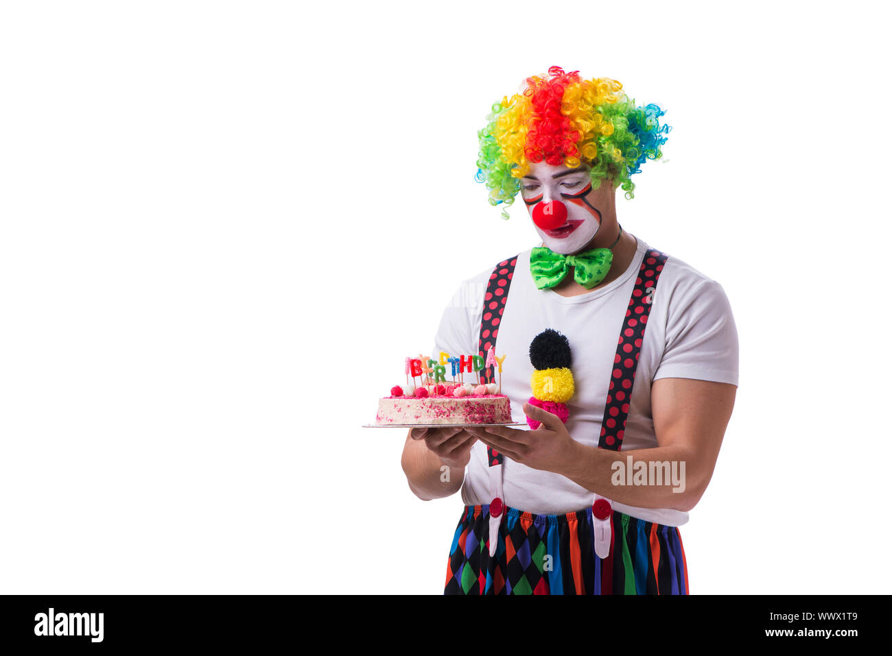 Der lustige Clown mit einem Geburtstagskuchen auf weißem Hintergrund Stockfoto