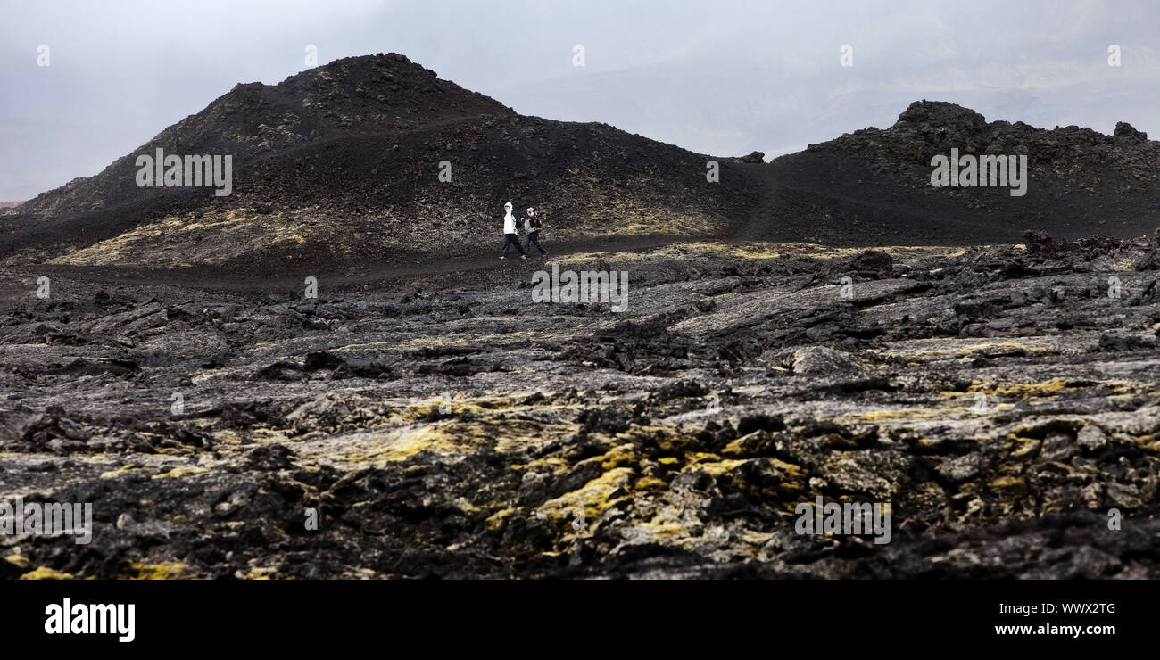 Touristen in Lavagestein der Krafla Vulkan, die geothermale Region Leirhnjukur im Hintergrund, Island, Europa Stockfoto