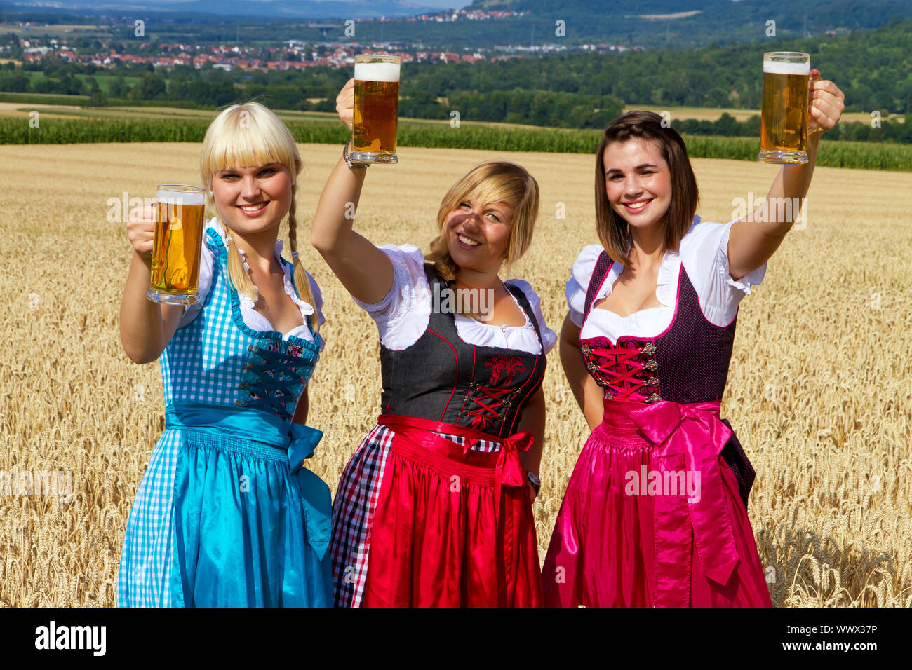 Mädchen im Dirndl Bier trinken in der Natur Stockfoto