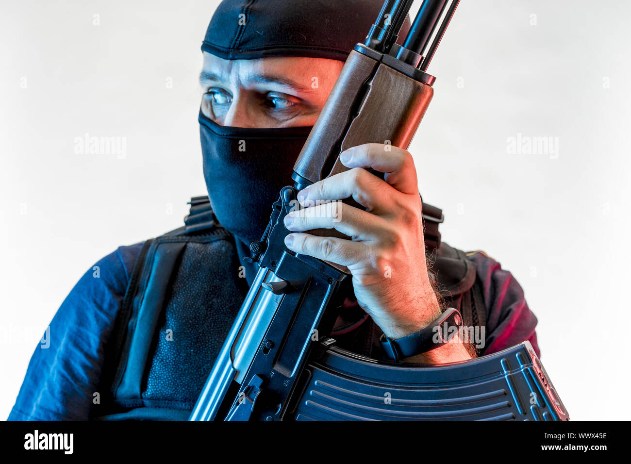 Bewaffneter Mann mit Sturmhaube und kugelsichere Weste, Pistole und Schrotflinte, kalaschnikow Stockfoto