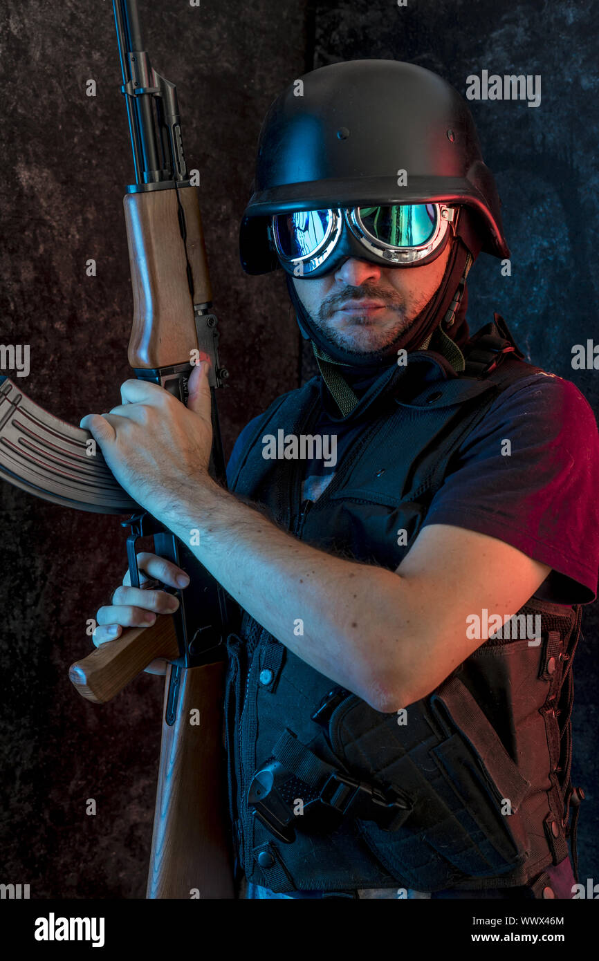 Gewalt, bewaffneter Mann mit Sturmhaube und kugelsichere Weste, Pistole und Schrotflinte, kalaschnikow Stockfoto