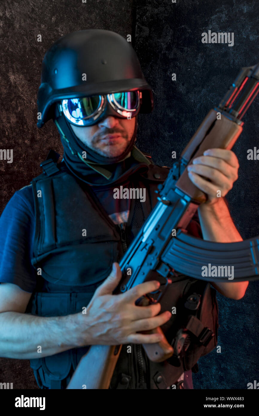 Bewaffneter Mann mit Sturmhaube und kugelsichere Weste, Pistole und Schrotflinte, kalaschnikow Stockfoto
