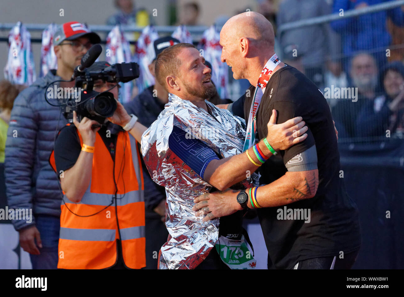 Tenby, Großbritannien. 15 Sep, 2019. Im Bild: Gareth Thomas (R) wird von ehemaligen Wales International Rugby Teamkollege Shane Williams durch die Ziellinie. Sonntag, 15 September 2019 Re: Ironman Triathlon Veranstaltung in Tenby, Wales, UK. Credit: ATHENA PICTURE AGENCY LTD/Alamy leben Nachrichten Stockfoto