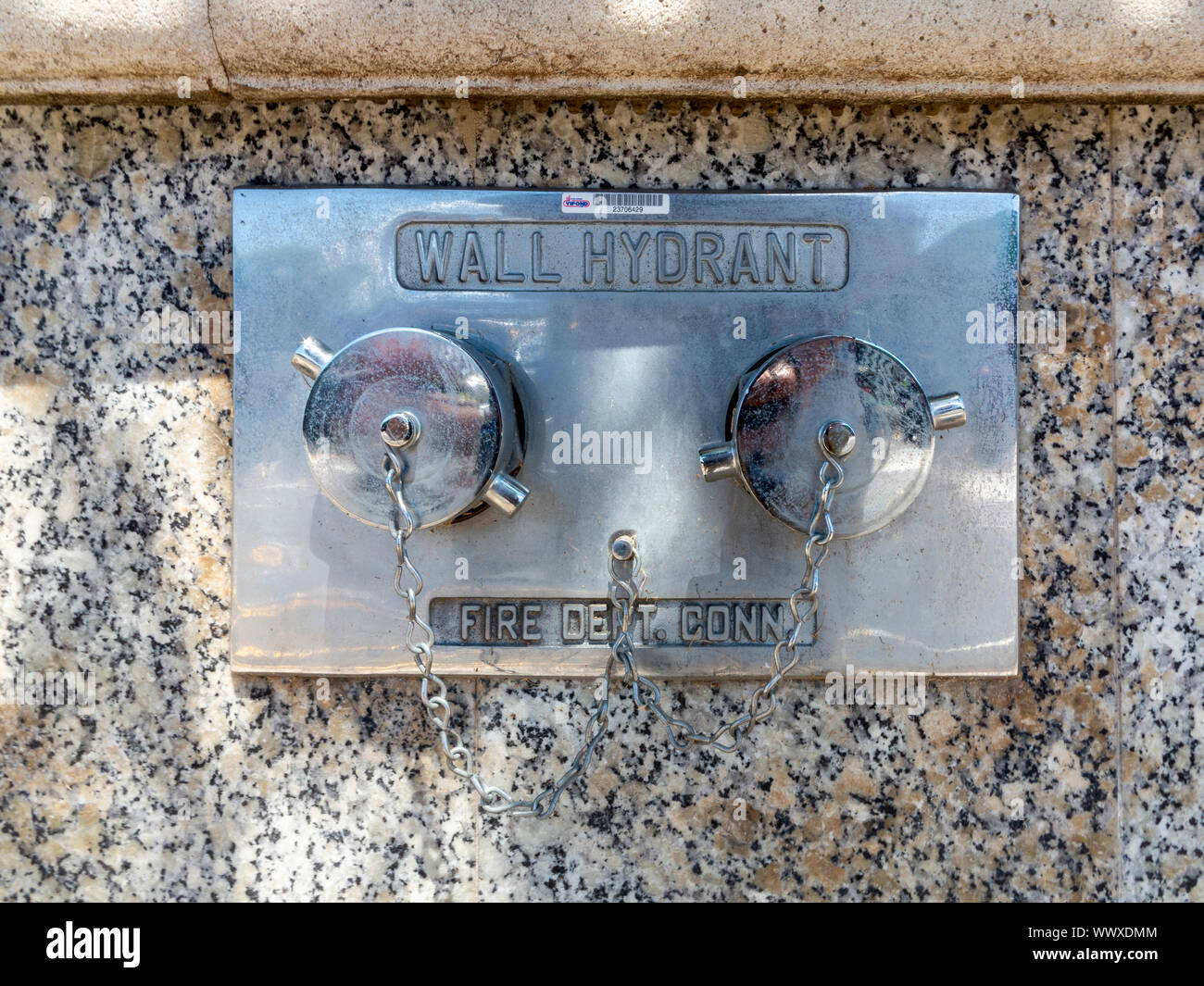 Eine doppelte Wand montiert Hydrant auf einer polierten Granit Wand in Hamilton, Bermuda Stockfoto