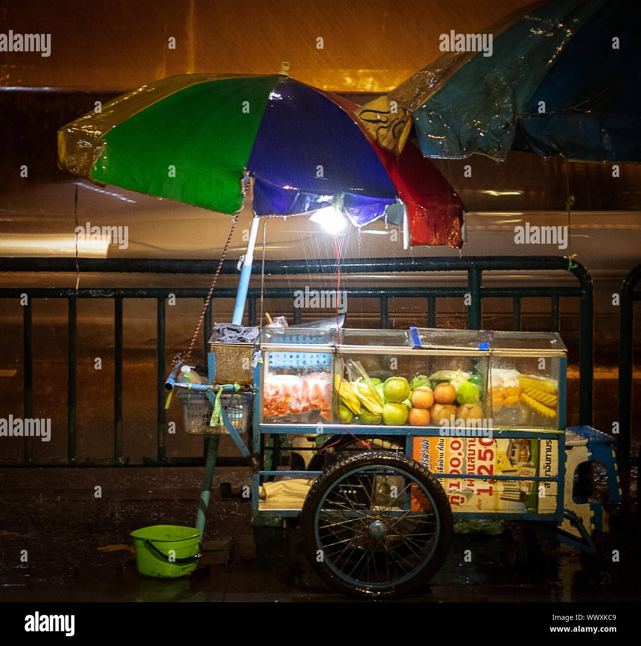 Ein regnerischer Abend in Bangkok. Auch die Frucht hat der Verkäufer innerhalb ausführen Stockfoto