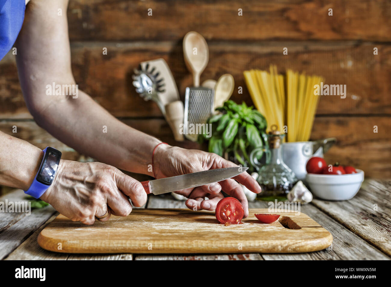 Eine Frau schneidet eine Cherry Tomaten und bereitet eine traditionelle italienische Pasta Stockfoto