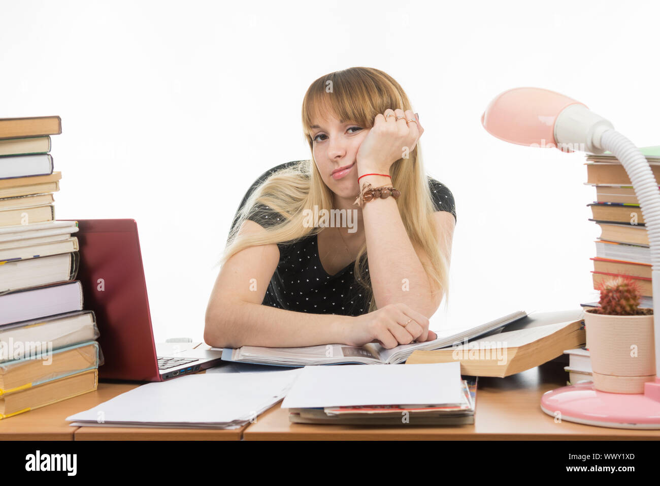 Student leider sitzen an einem Tisch unter den Stapel von Büchern und Papieren Stockfoto