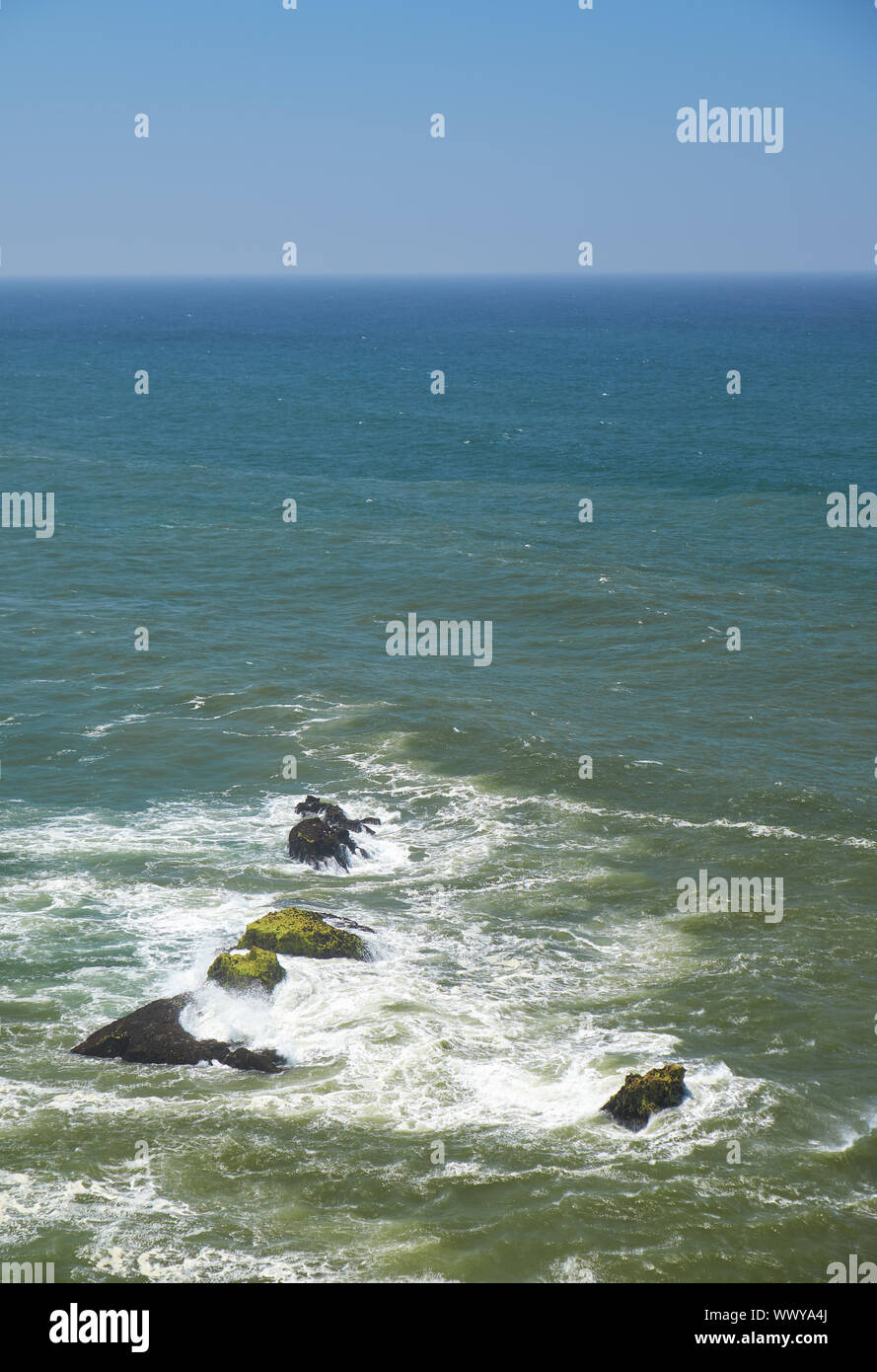 Felsen und Wellen surfen im Meer in der Nähe von Farol De Nazare Küste in Portugal Stockfoto