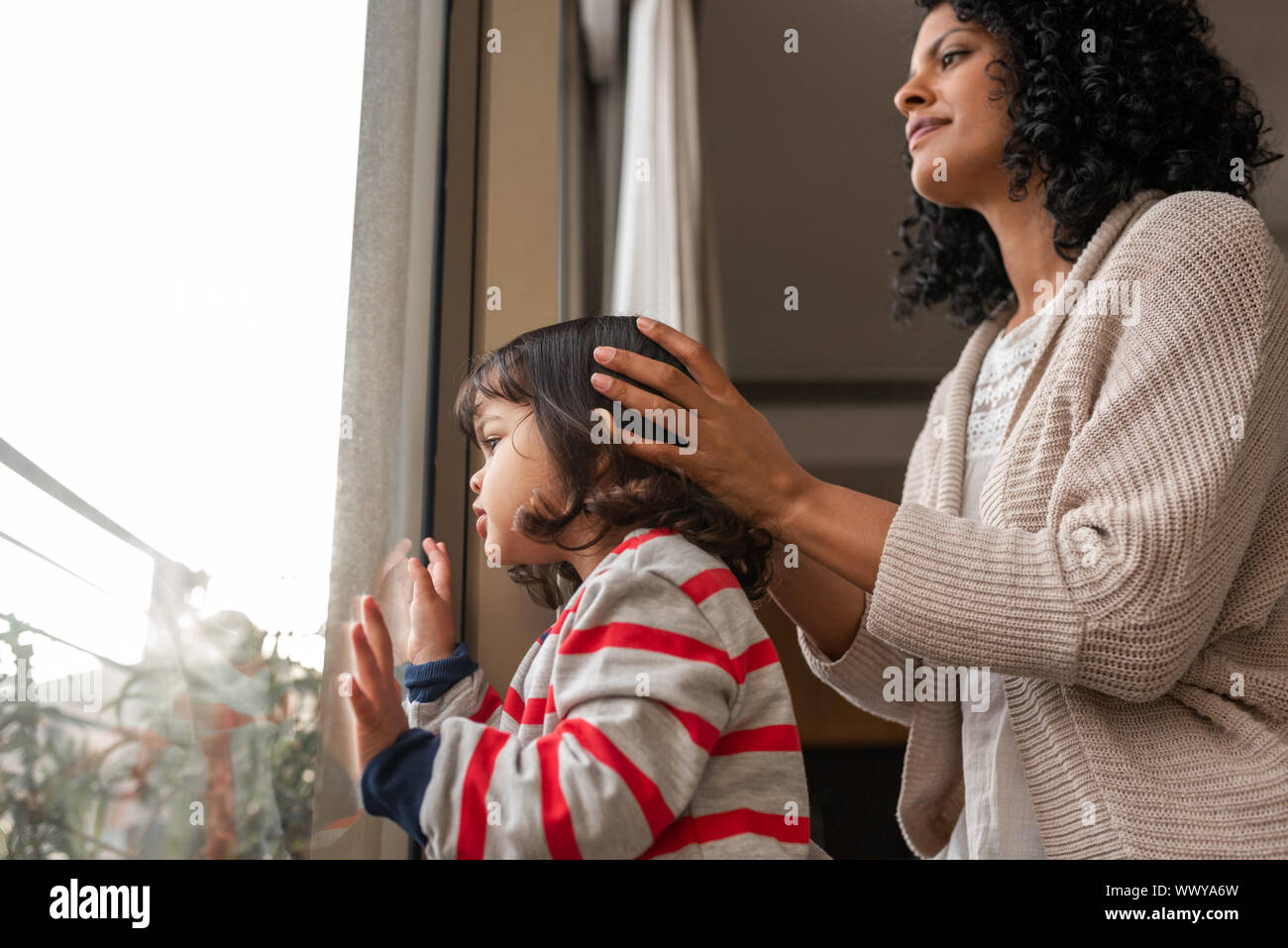 Kleine Mädchen und ihre Mutter durch ein Fenster Stockfoto