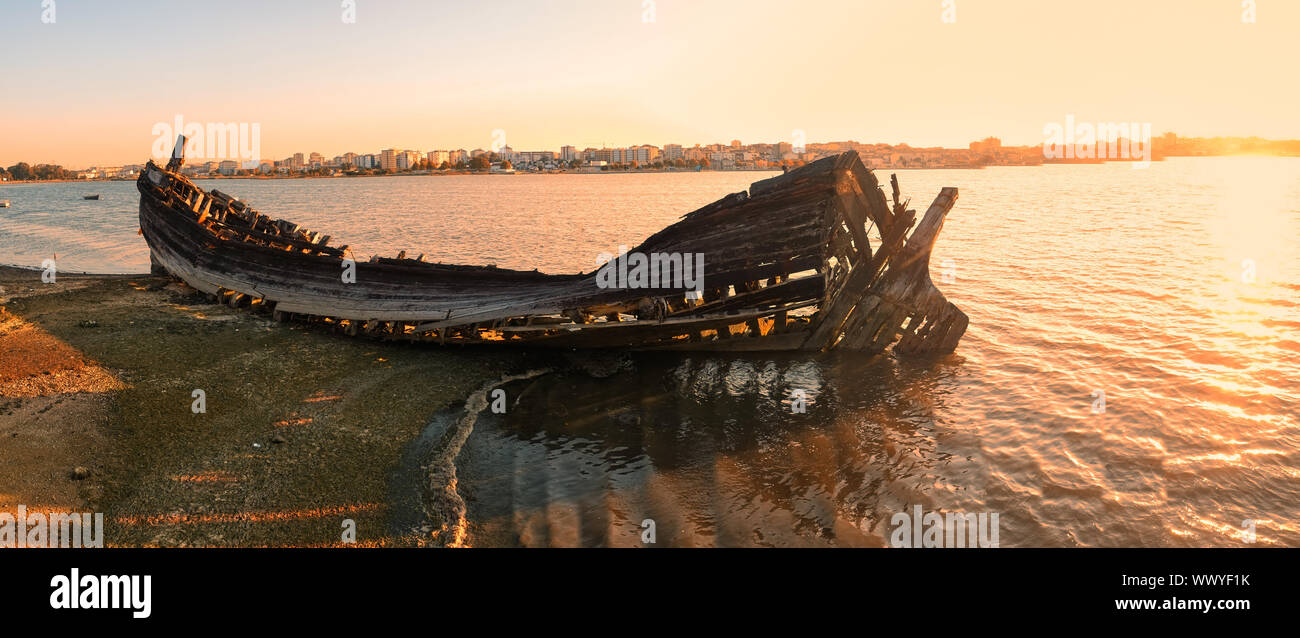 Die Wracks von einer gebrannten Boot am Ufer des Seixal Bucht im Abendlicht. Lissabon. Portugal Stockfoto