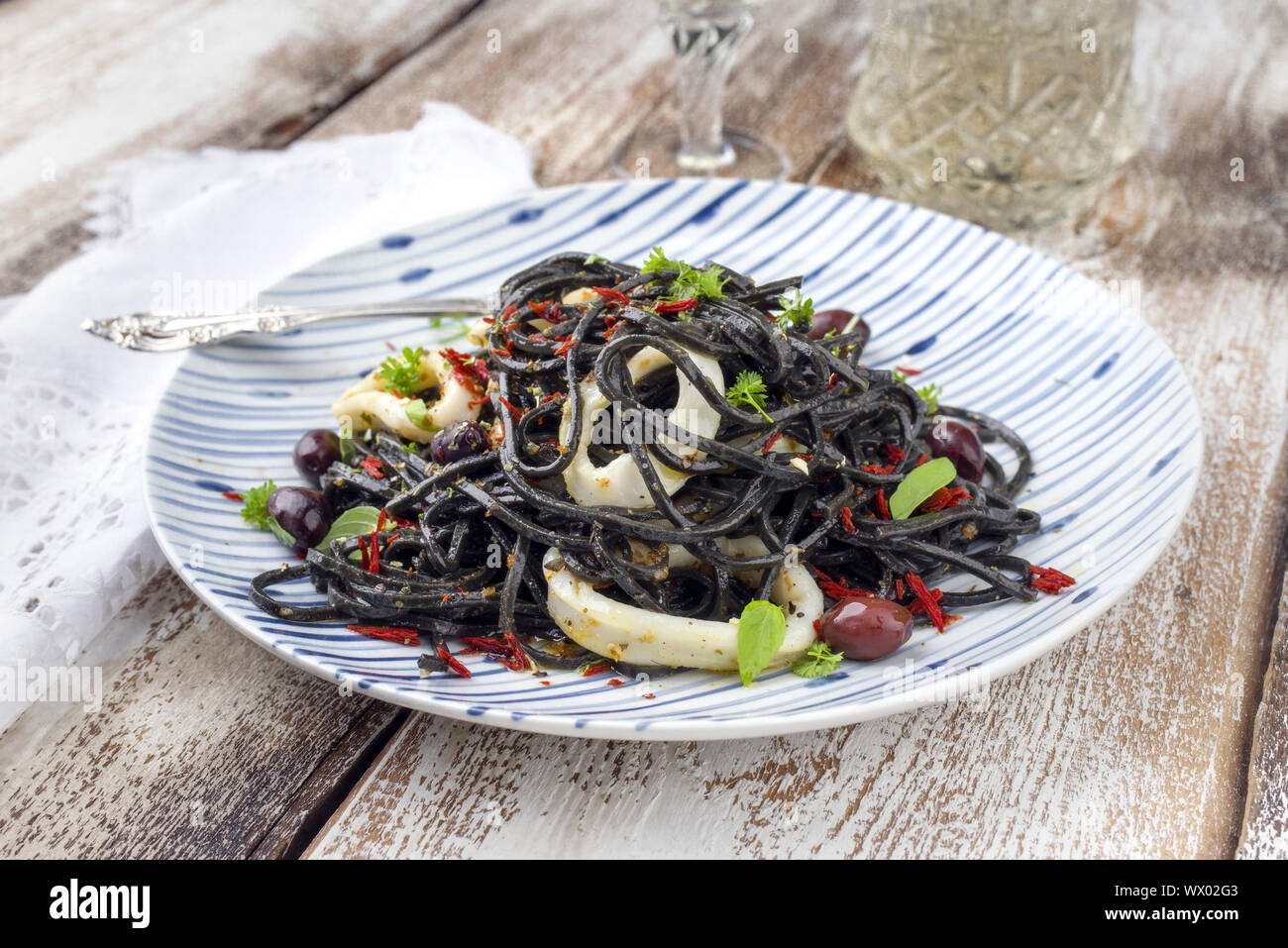Italienische linguine con Tinta de Calamari mit Oliven als Close-up auf einer Platte Stockfoto