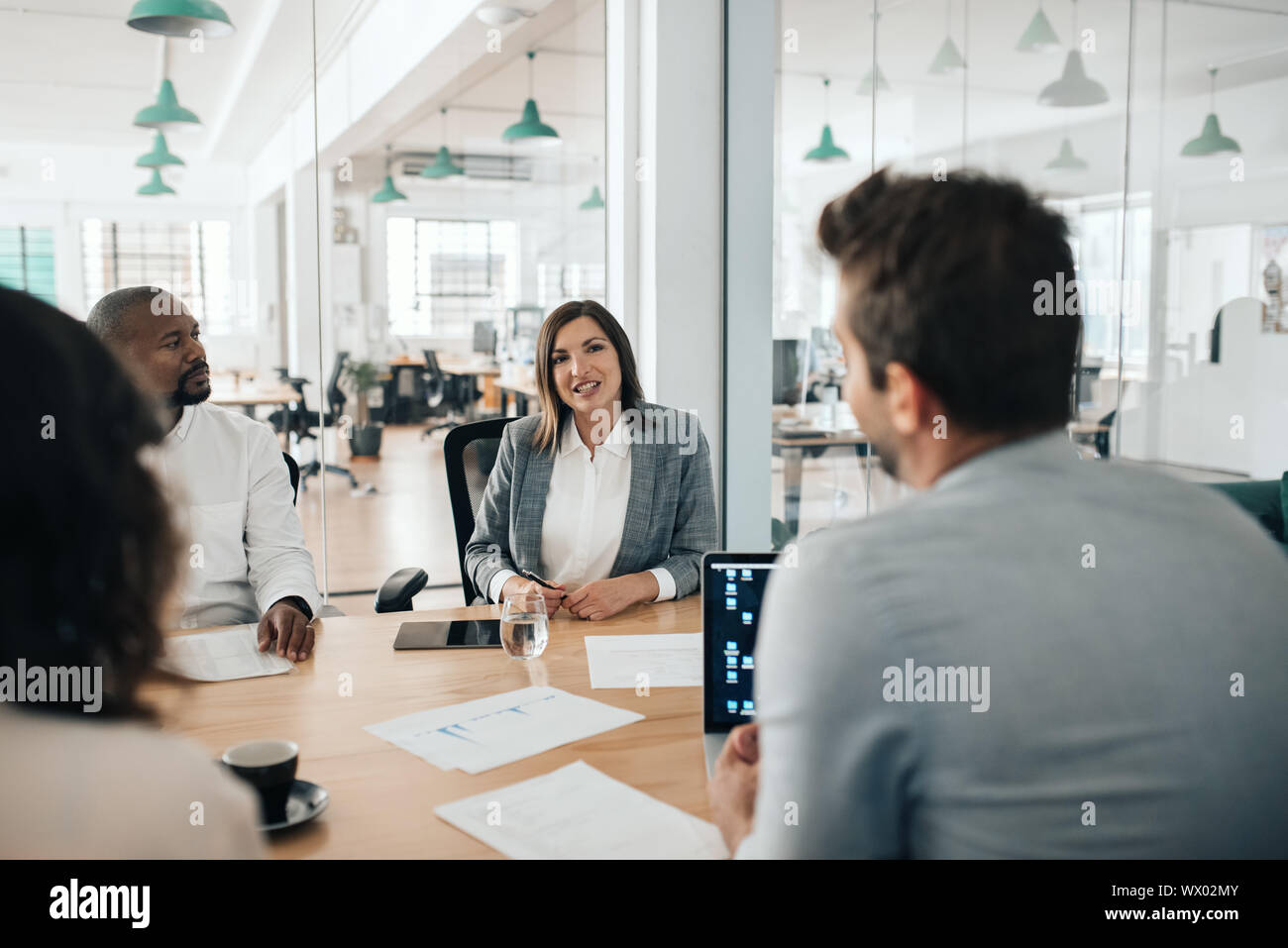 Lächelnd Geschäftsfrau im Gespräch mit Kollegen während einer Konferenz Stockfoto