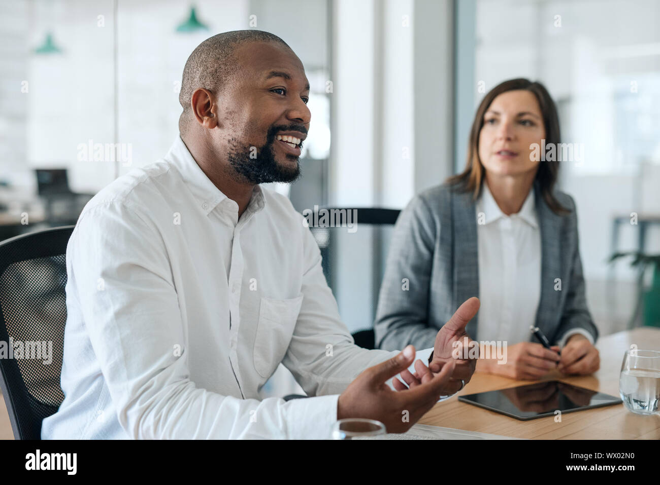 Lächelnd Afrikanische amerikanische Geschäftsmann im Gespräch mit Kollegen während einer Konferenz Stockfoto