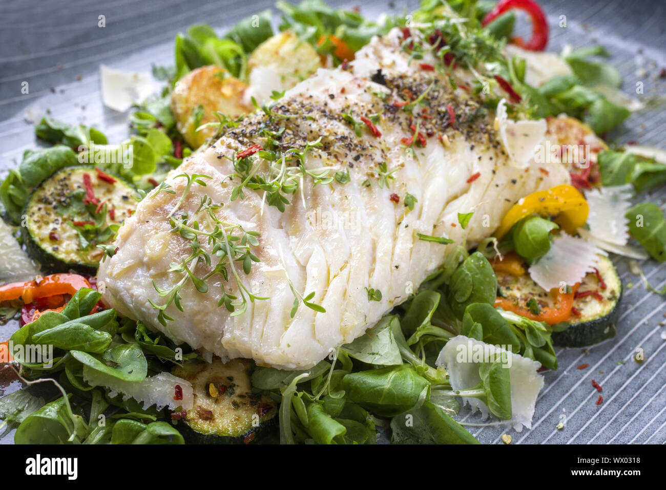 Frittierter Kabeljau Filet mit Salat und Gemüse als Close-up auf einer Platte Stockfoto