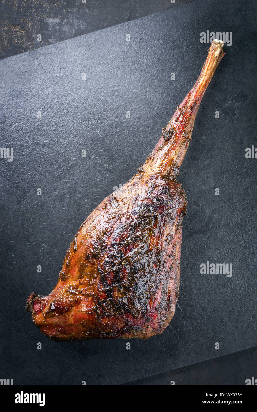 Grill Rehkeule mit Marinade als Close-up auf einer Schiefertafel Platte Stockfoto