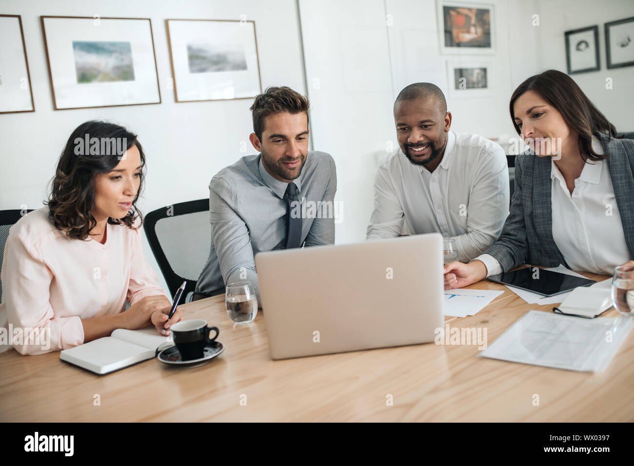 Diverse Geschäftsleute Lächeln beim zusammen, die an einem Notebook arbeitet Stockfoto