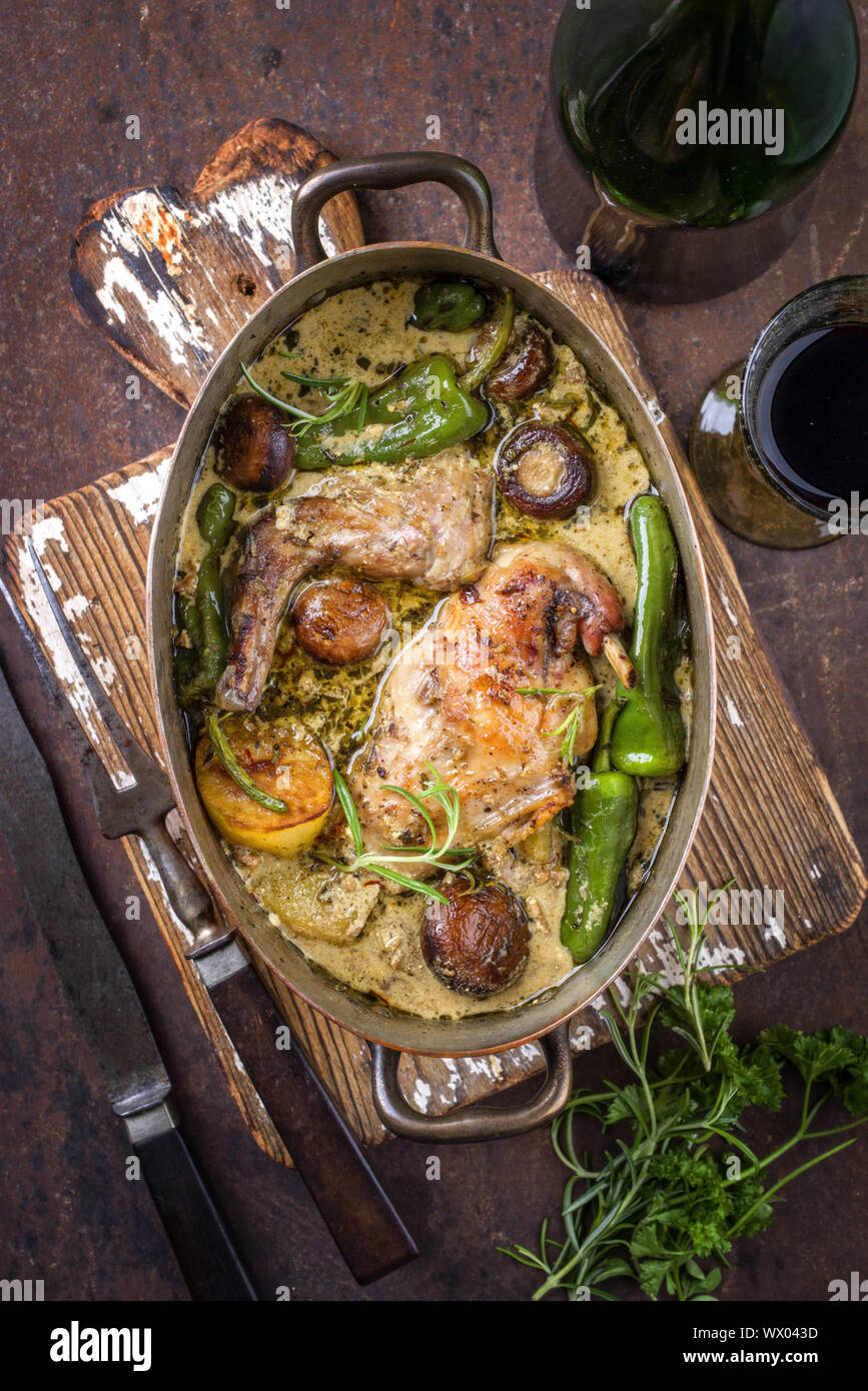 Kaninchen mit Gemüse und Champignons in Weißwein-Sahnesoße, Ansicht von oben in einem Stewpot Stockfoto