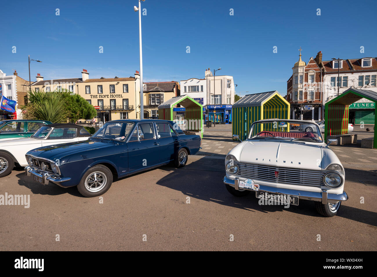 Autos am Strand Car Show an der Marine Parade, Southend On Sea, Essex, Großbritannien. Ford Cortina und Hillman Minx klassische Autos mit farbigen Unterstände Stockfoto