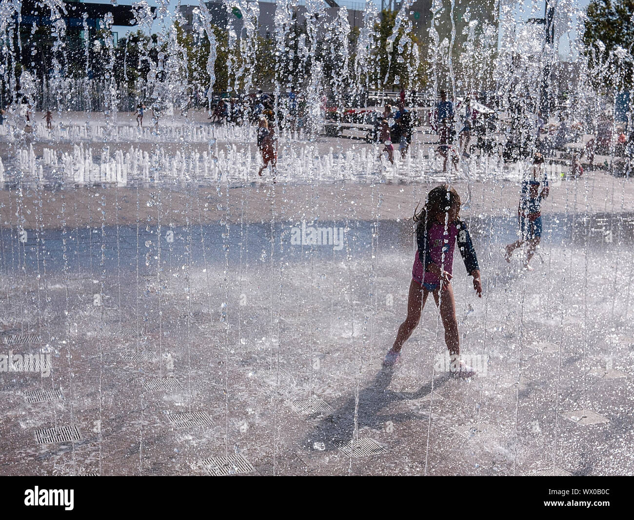 Kinder beim Spielen im Brunnen in Granery Sq Kings Cross London UK Stockfoto