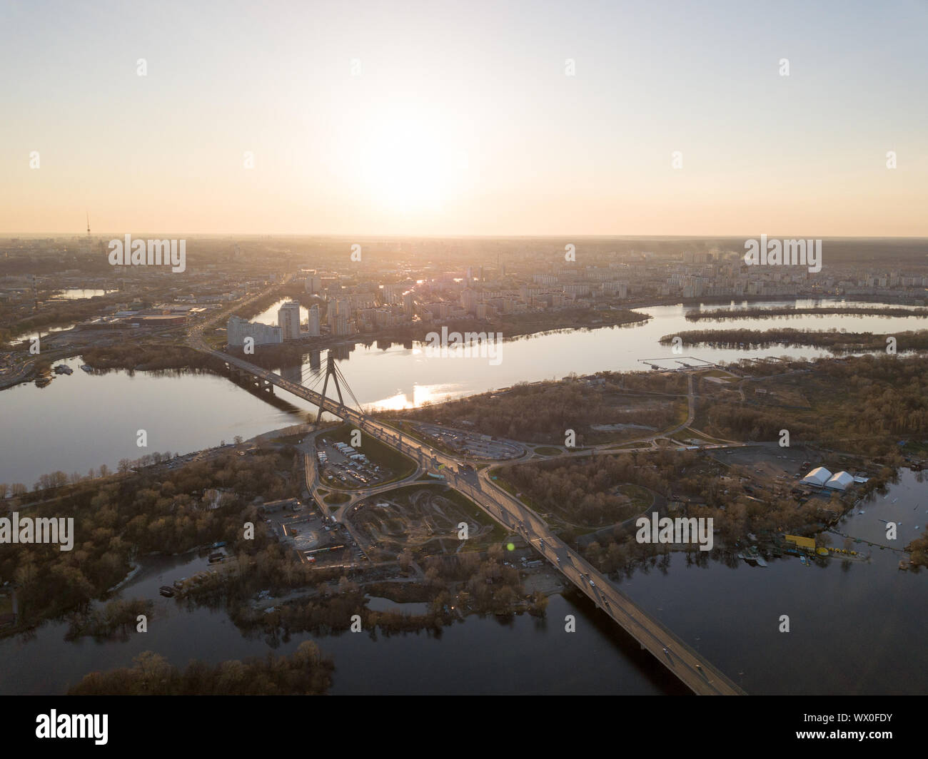 Die Brücke über den Fluss Dnepr und einen Panoramablick auf die Stadt Kiew bei Sonnenuntergang. Stockfoto