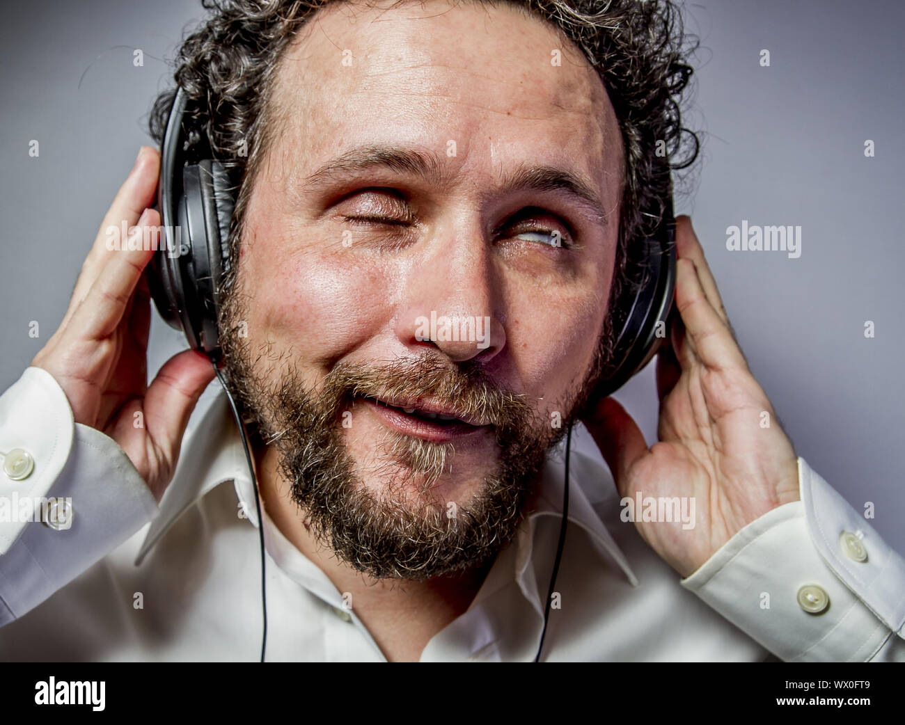 Genießen Sie die Musik, Mann mit intensiven Ausdruck, weißes Hemd Stockfoto