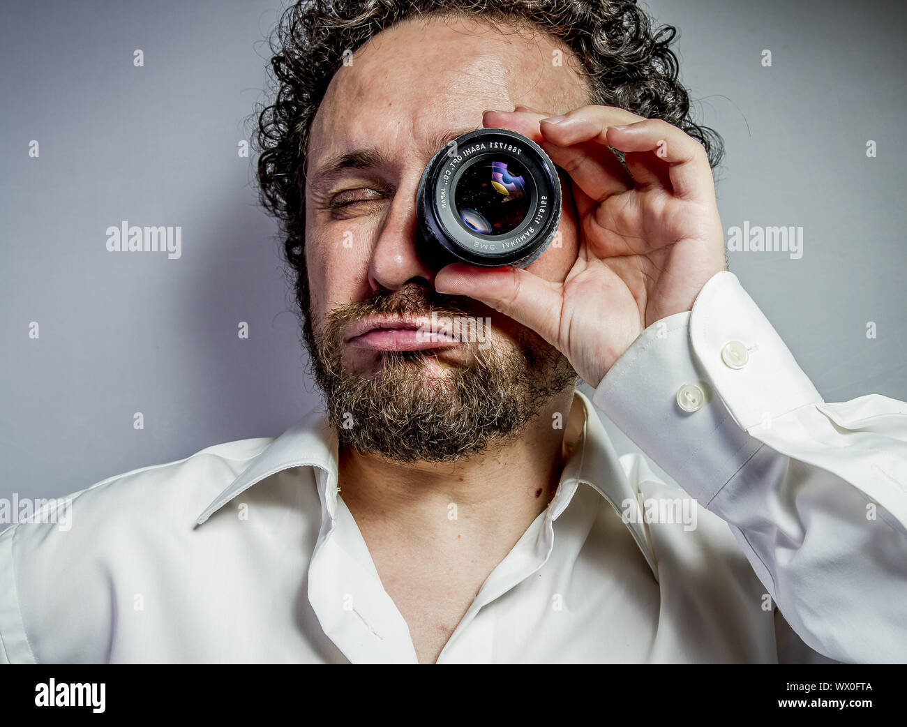 Fotograf mit Objektiv, Mann mit intensiven Ausdruck, weißes Hemd Stockfoto