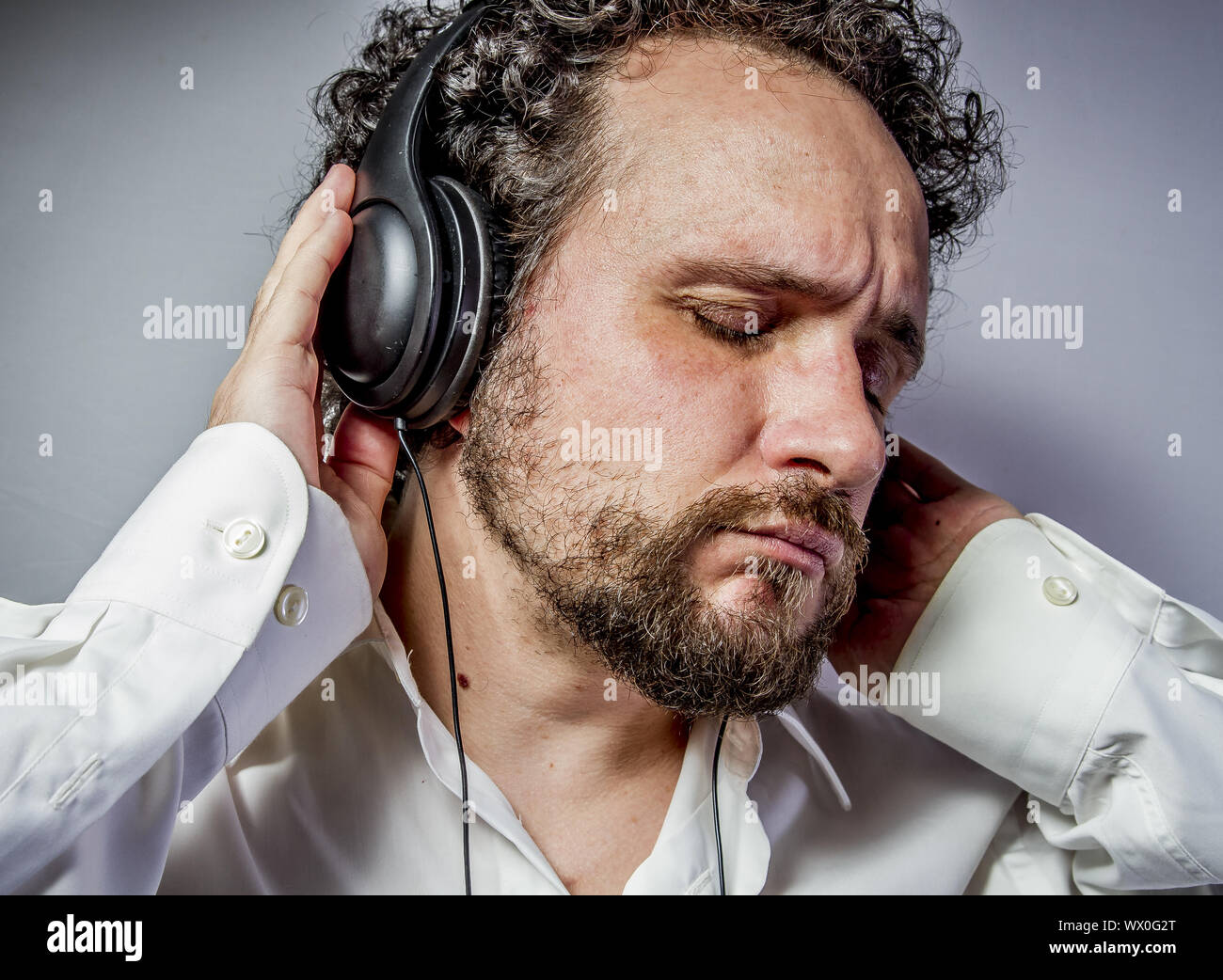 Genießen Sie die Musik, Mann mit intensiven Ausdruck, weißes Hemd Stockfoto