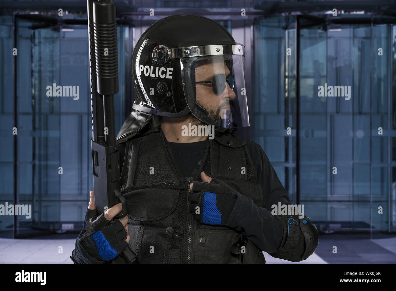 Polizisten mit Riot Helm und Weste in einem Business Center Schutz Stockfoto