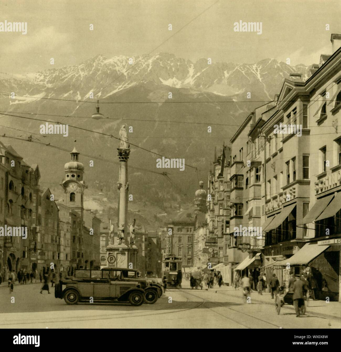 Maria-Theresien-Straße, Innsbruck, Tirol, Österreich, c 1935. Straße benannt nach Königin Maria Theresia, mit Blick auf St Anne's Spalte und die Alpen im Hintergrund. Das Denkmal comemmorates der Vertreibung der letzten bayerischen Truppen aus Tirol auf St. Anne's Day (26. Juli) 1703, während des spanischen Erbfolgekrieges. Von "&#xd6; Österreich - Land und Volk", (Österreich, Land und Leute). [R. Lechner (Wilhelm M&#xfc;ller), Wien, c 1935] Stockfoto