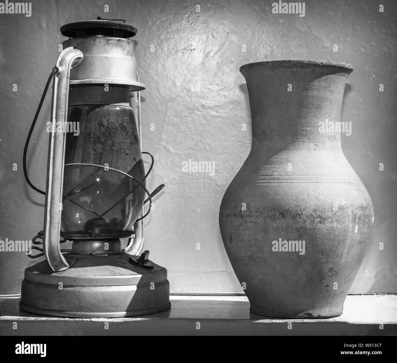 Antike Objekte des Alltags: eine Petroleumlampe und ein Krug. Stockfoto