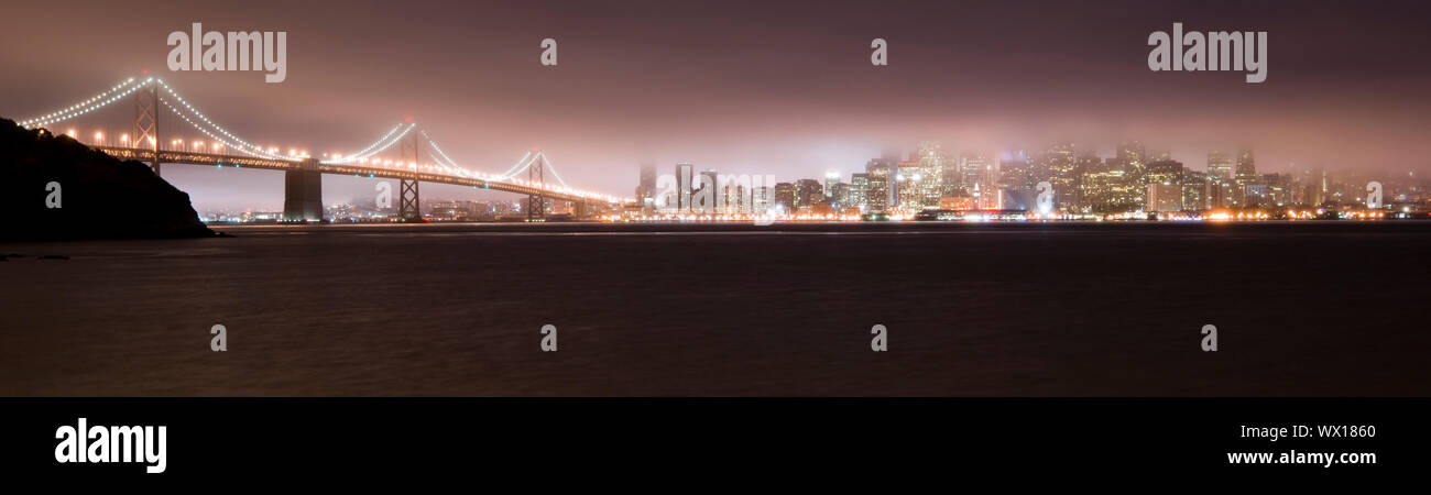 Bay Bridge und San Francisco im Nebel bei Nacht Stockfoto