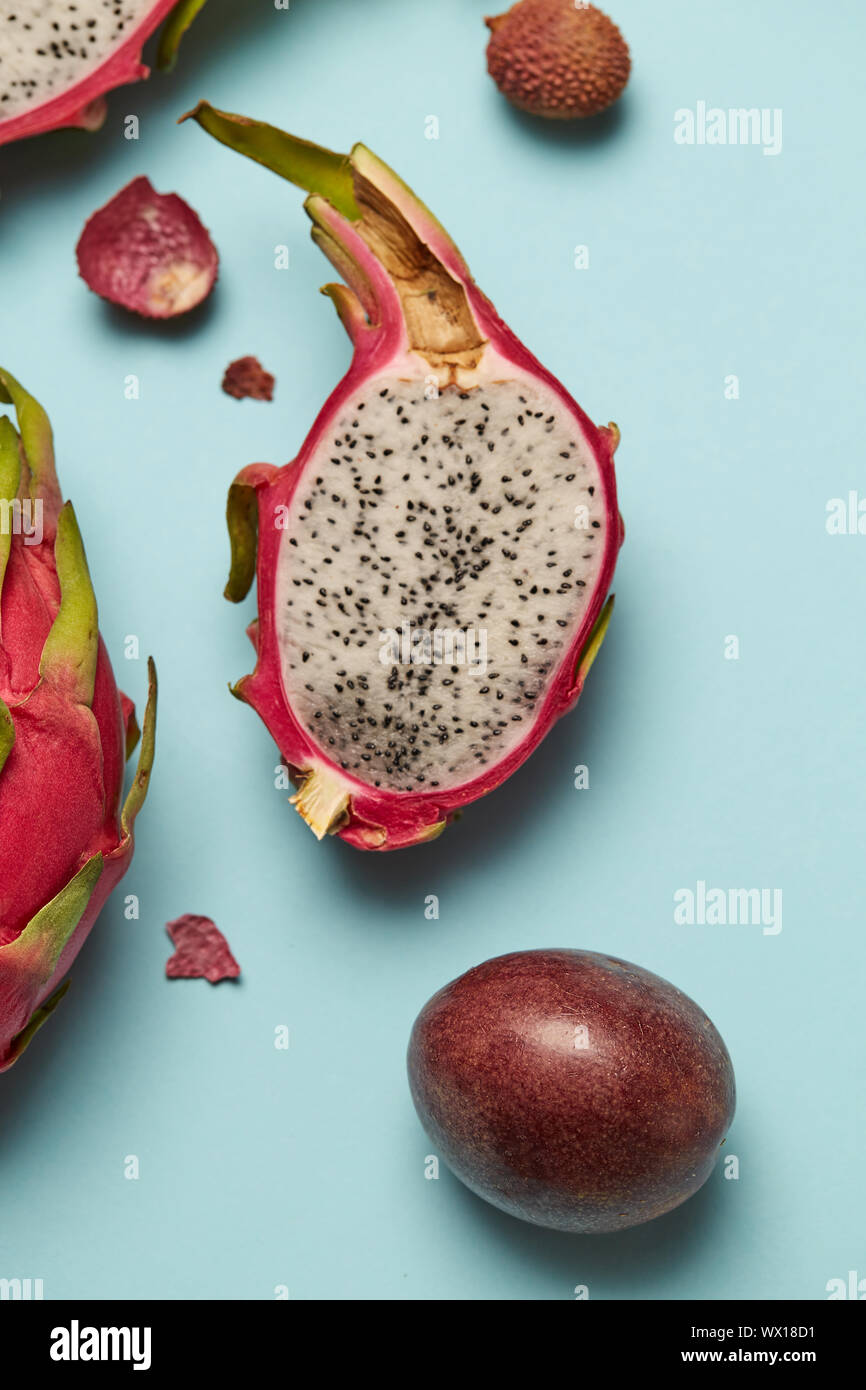 Exotische halbe Frucht Drachenfrucht mit Rosa und grüne Haut auf blauem Hintergrund Stockfoto