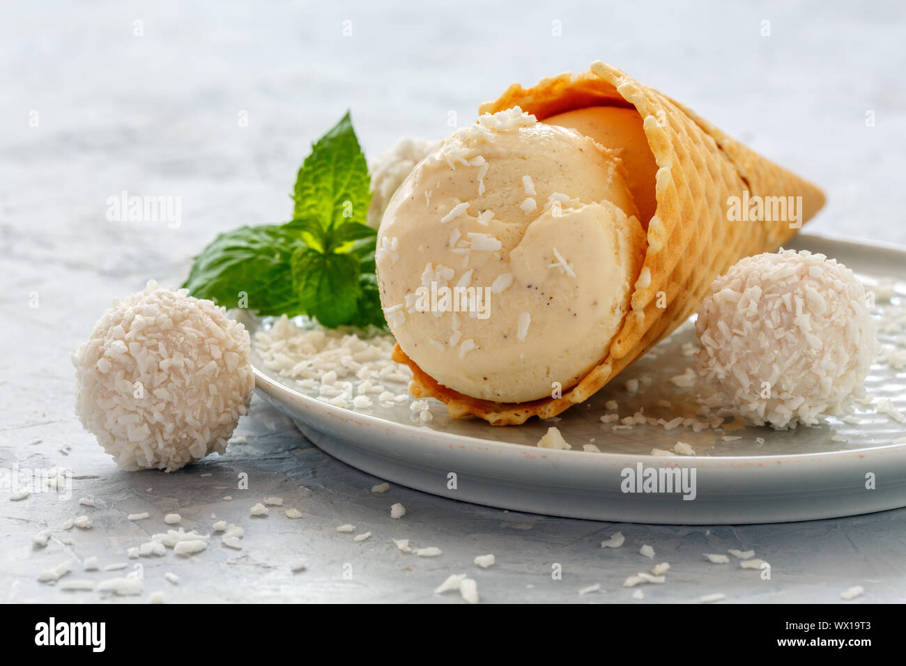Kokosnuss Eis in der Waffel Kegel, Kokosraspeln und Minze. Stockfoto