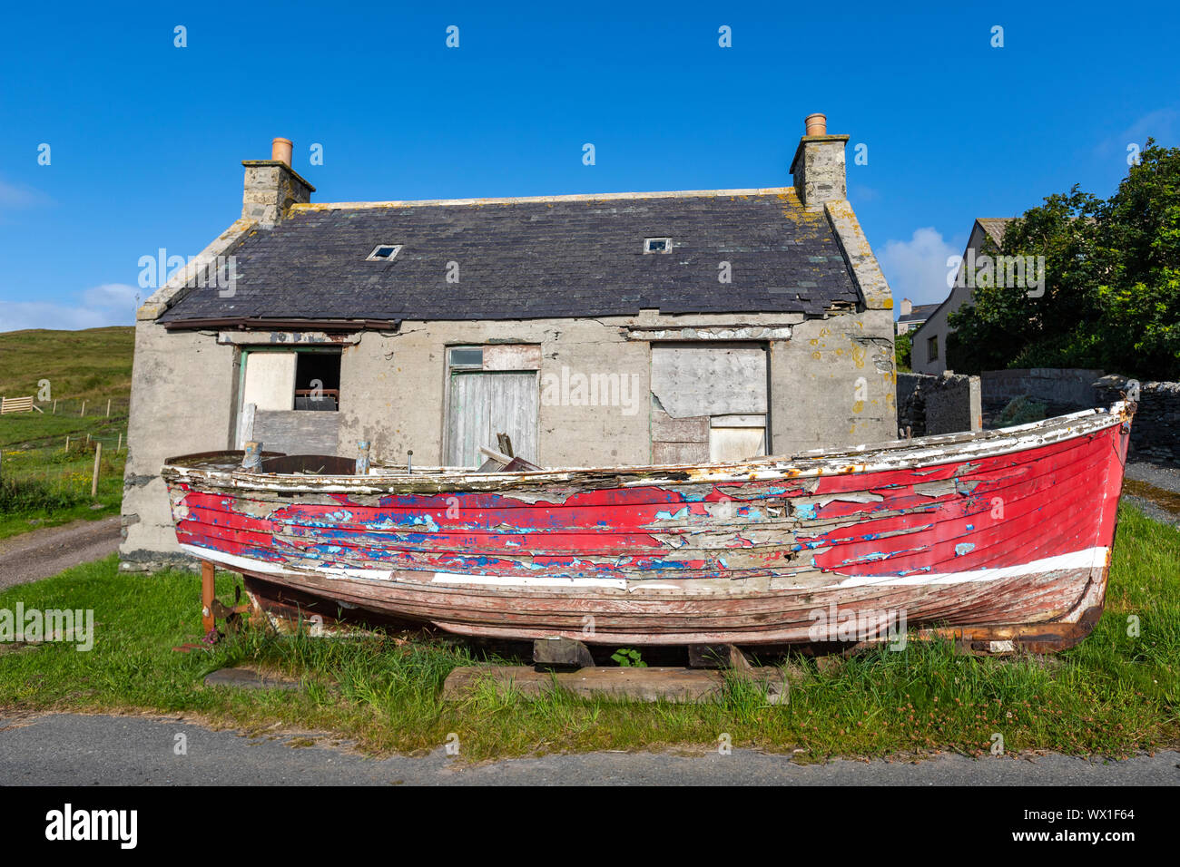 Abziehbarer Farbe Boot vor die Abbruch Cottage im Cunningsburgh, Festland, Shetlandinseln, Schottland, Großbritannien Stockfoto