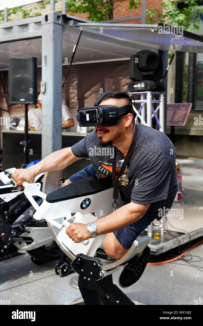 Ein Mann mit Virtual reality Brillen und Reiten ein Motorrad Simulator Stockfoto