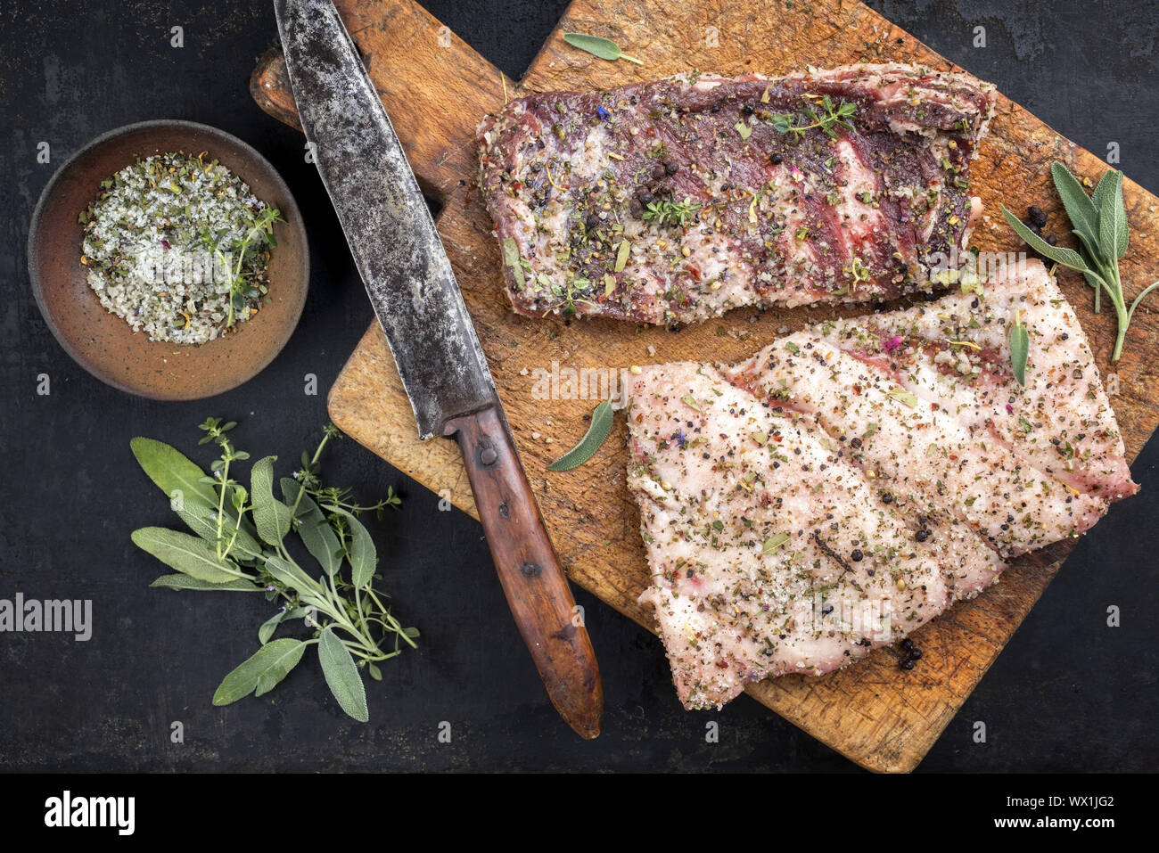 Ausgehärtete wild Schweinebauch mit Gewürzen wie Draufsicht auf einem alten Schneidebrett Stockfoto