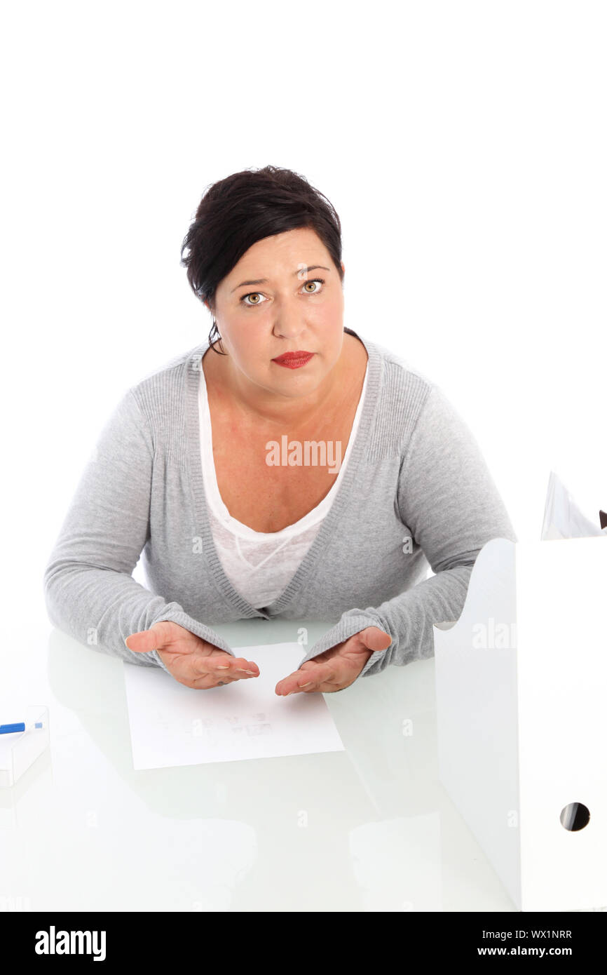 Hohe Betrachtungswinkel und einer Frau mittleren Alters an einem Tisch mit einem Blatt Papier vor sich, ihren Fall plädieren sitzt Stockfoto