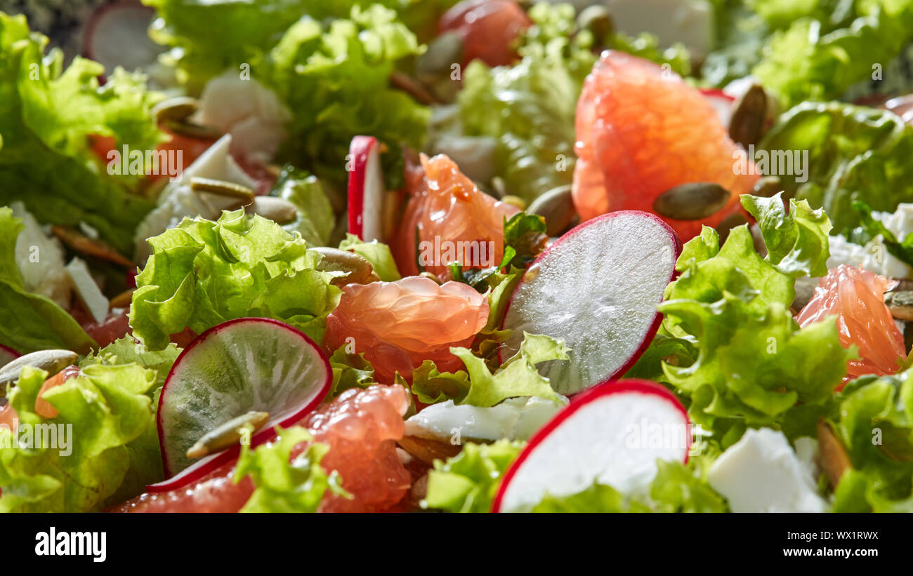 Frisch grünen im vegetarischen Salat abgeholt - Salat, Radieschen, Grapefruit, Käse, Kürbiskerne. Stockfoto