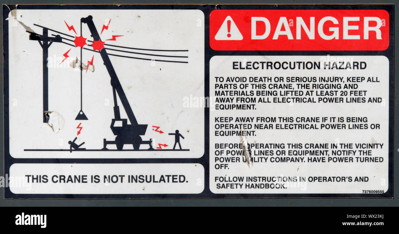 Ein Warnschild an einem Ausleger Kran, die zeigen, dass der Kran nicht von electroc Schock von Oberleitungen isoliert Stockfoto Ein Warnschild an einem Ausleger Kran, die zeigen, dass der Kran nicht von electroc Schock von Oberleitungen isoliert Stockfoto