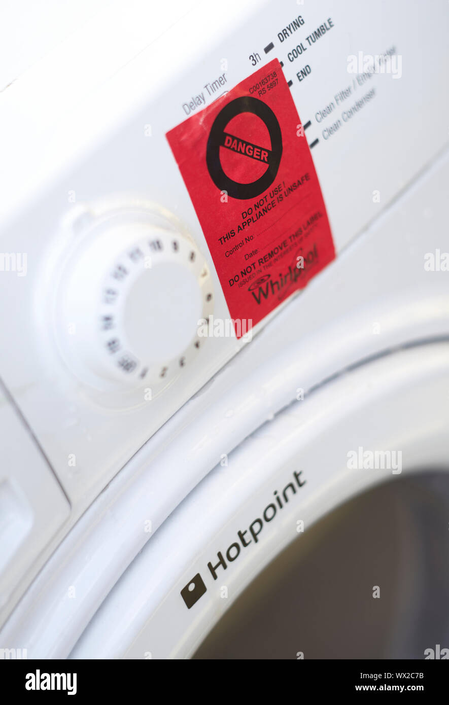 Rote Warnschild klemmt auf der Vorderseite eines weißen Knallerkauf Whirlpool Wäschetrockner Stockfoto