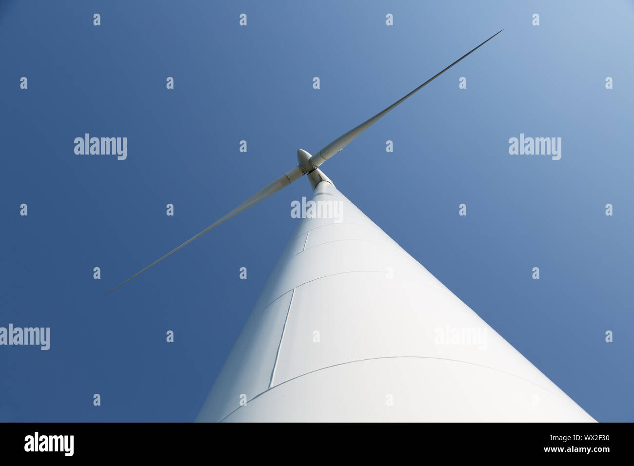Auf der Suche nach oben auf eine große Windkraftanlage und ein blauer Himmel Stockfoto