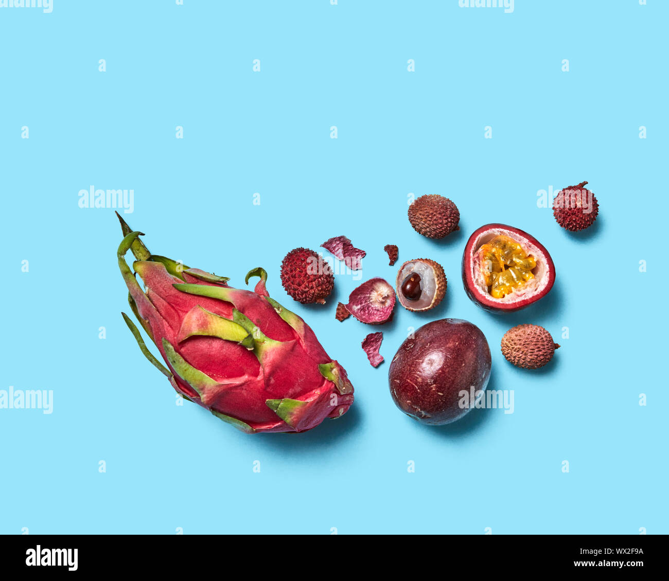 Saftige Hälften, ganze schälen und Früchte litschi Passionsfrucht und  pitahaya auf einem blauen Hintergrund mit Platz für Text. Flach  Stockfotografie - Alamy