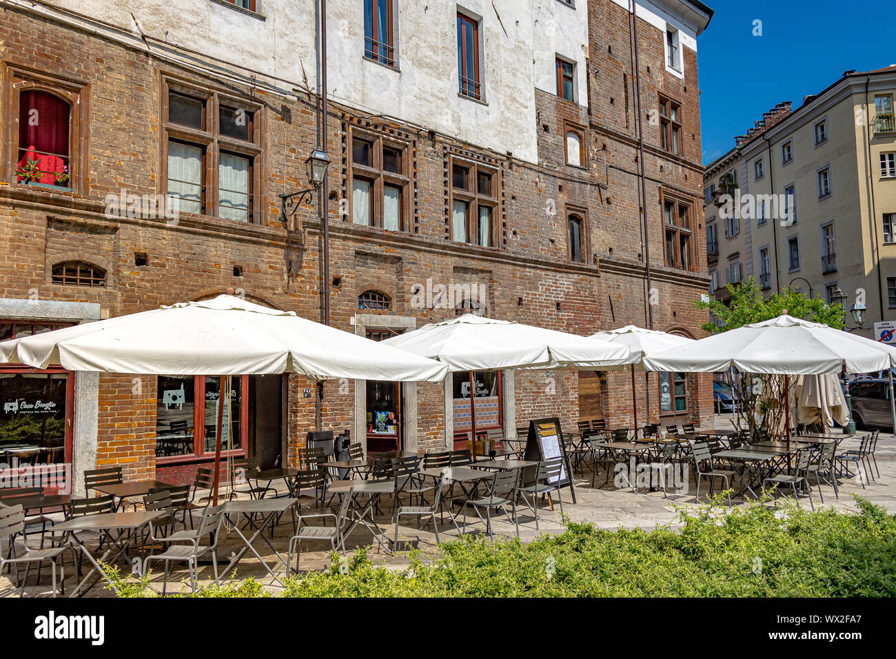 Tische und Stühle mit Sonnenschirmen außerhalb Casa Broglia, einem italienischen Restaurant in Turin, Italien Stockfoto