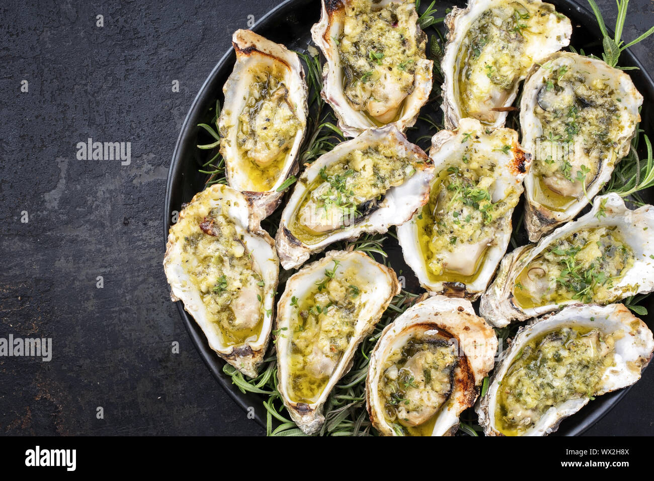 Grill overbaked frische Austern mit Knoblauch und Kräuter als Draufsicht auf einem Tablett mit Kopie Raum angeboten geöffnet Links Stockfoto