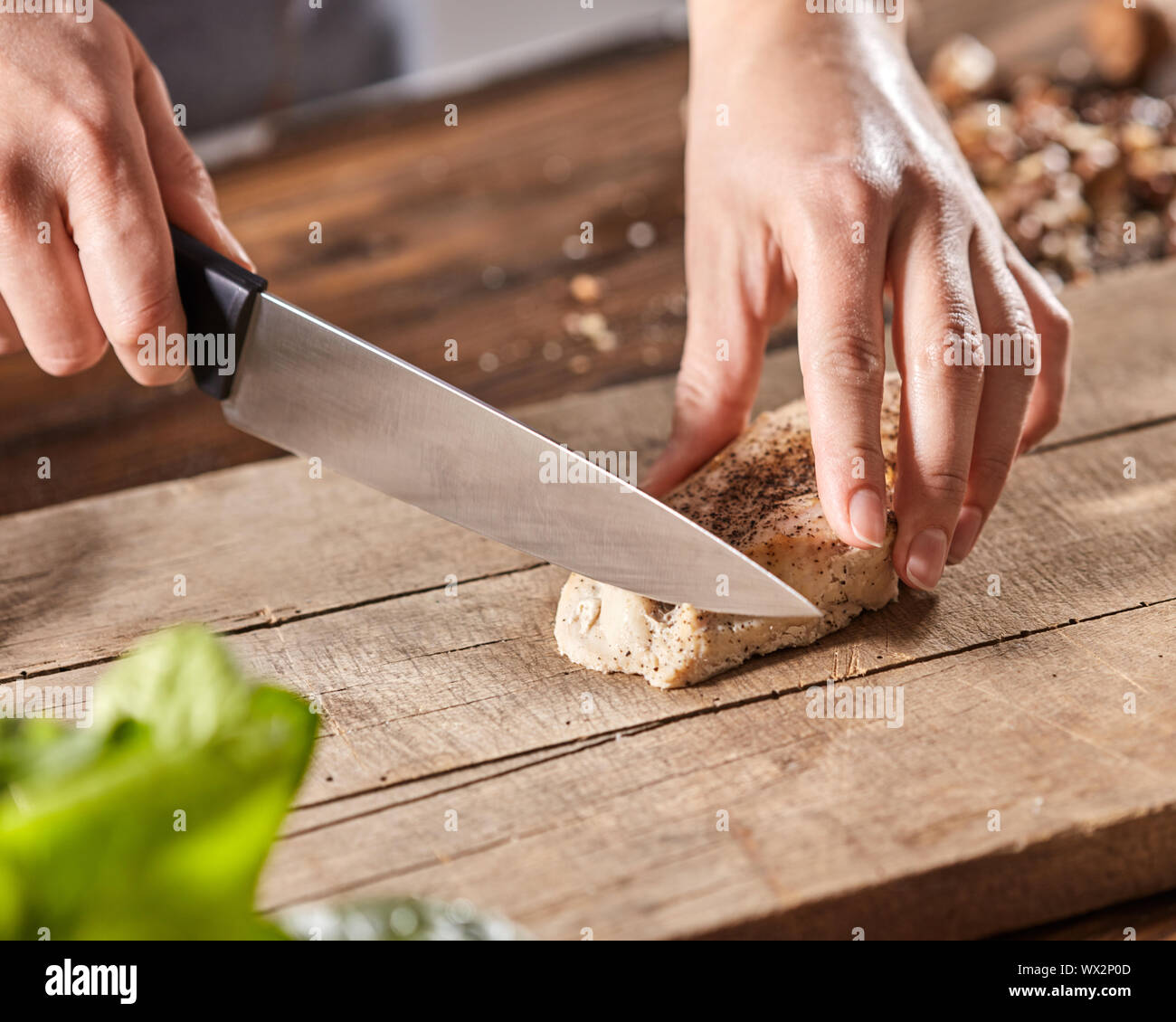 Die Hände der Frau sind, Schneiden von Fleisch auf einem Holzbrett auf  einem alten Holztisch. Schritt-für-Schritt kochen Stockfotografie - Alamy