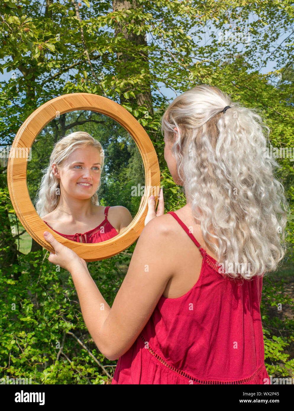 Blonde Frau an ihrem Spiegelbild suchen Stockfoto