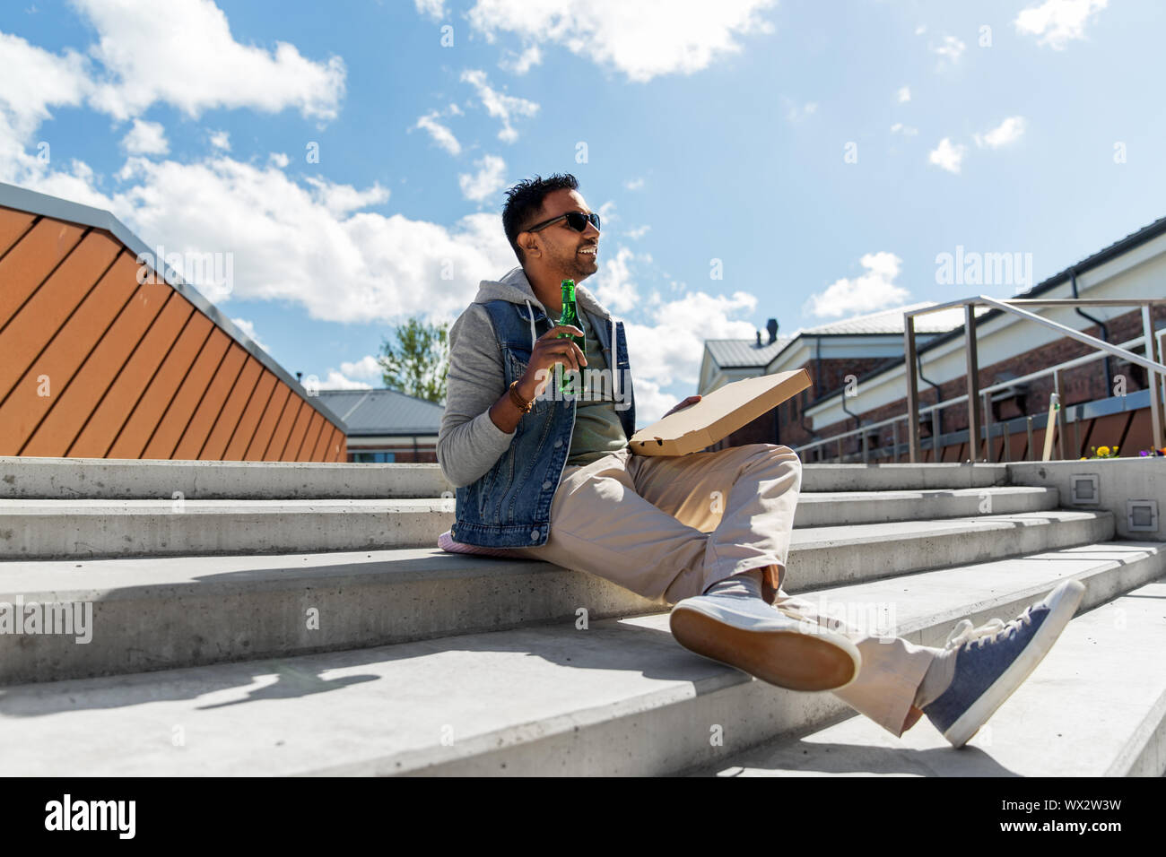 Inder mit Pizza und Bier im Freien Stockfoto
